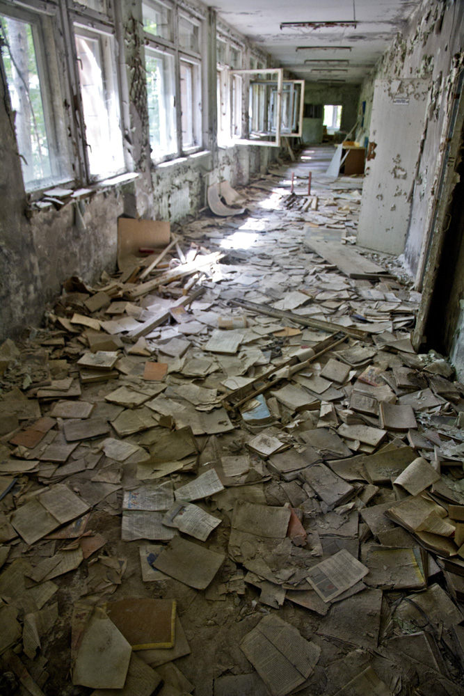 scattered, discarded books in a building in Chernobyl