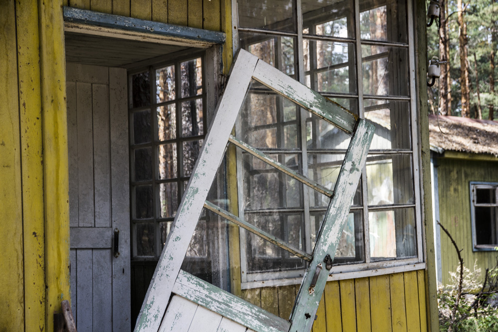 door falling off of an abandoned wood cabin in the summer camp area of Chernobyl