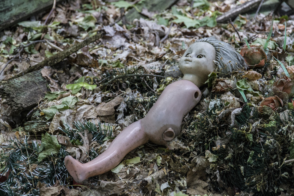 toy doll in leaves outside a school building in Chernobyl