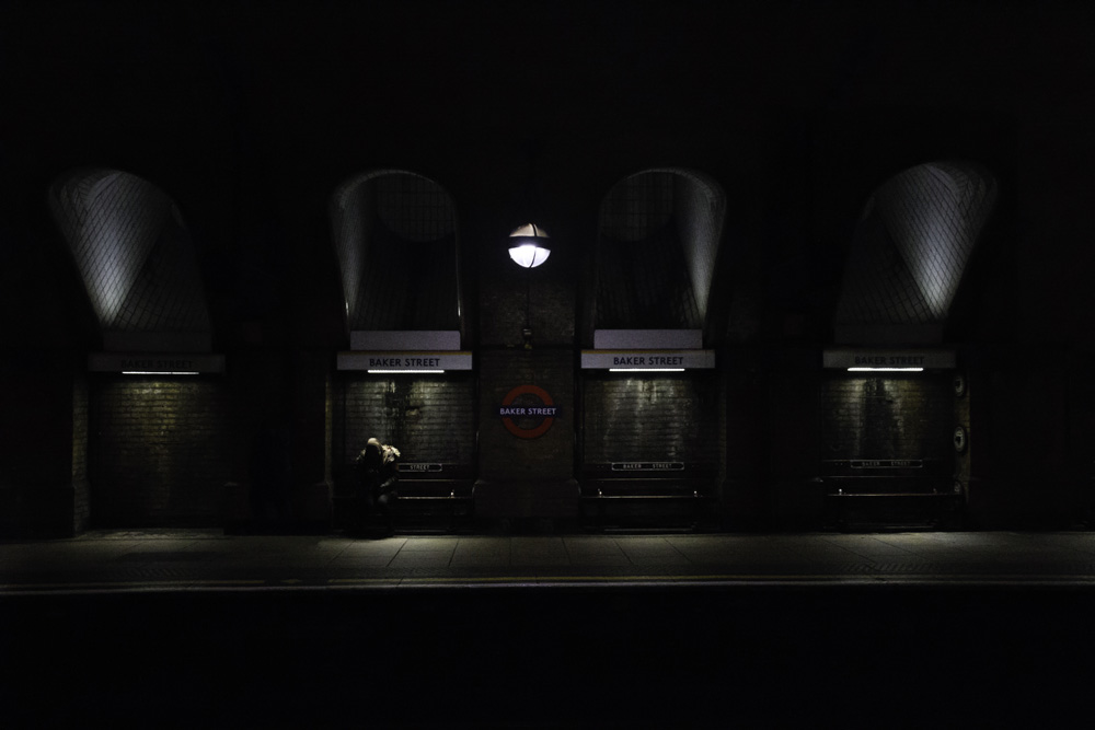 a person waits for a train in Baker Street tube station, London